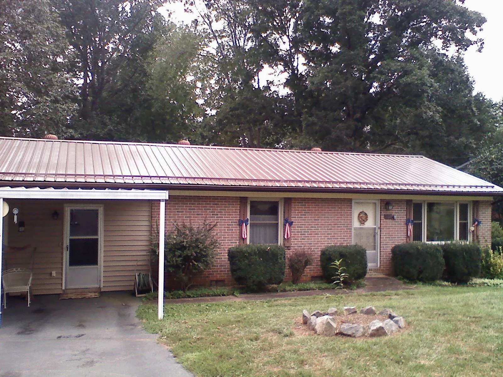 Bronze metal roof and carport on a brick ranch home — Roof Repair work by our crew in Centerport